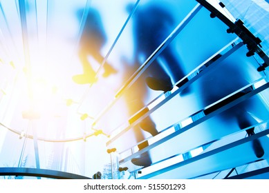 Silhouette people walking on glass staircase - Powered by Shutterstock