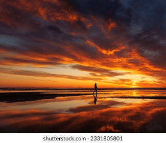 silhouette person against background beautiful sunset sky on ocean, reflection rays sun and sky in water. Freedom inspiration in nature under open sky enjoys beautiful view and meditates, happiness - Powered by Shutterstock
