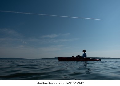 The Silhouette Of A Person Kayaking On Lake Superior