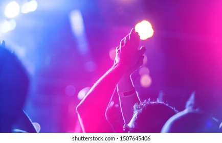 Silhouette photo of Christian worship God together in Church hall in front of music stage Night of worship.Raised hand and praise worship the LORD.Christian concert background.