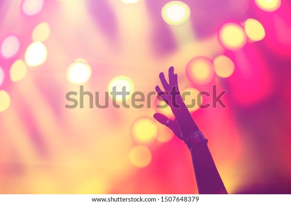 Silhouette photo of\
Christian worship God together in Church hall in front of music\
stage Night of worship.Raised hand and praise worship the\
LORD.Christian concert\
background.