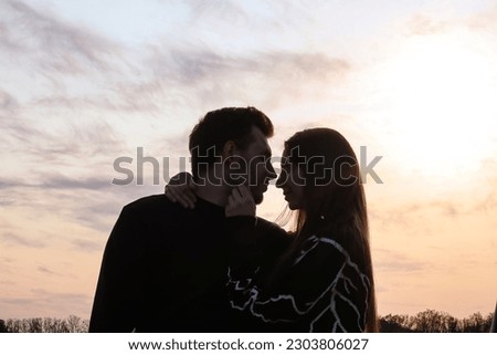 Silhouette photo of a couple in love at sunset.Portrait of a man and a woman.Photo at sunset.Silhouette portrait.Romantic photo.Hugs of a couple in love.Sensual photo.Date.look into each other's eyes