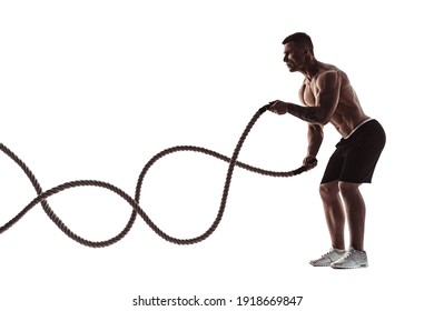 Silhouette photo of a muscular man working out with heavy ropes isolated on white background.