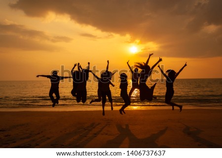 Silhouette photo of the team celebration on the beach at sunset