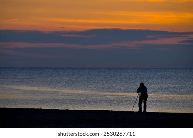 Silhouette of a photographer capturing the beauty of the sunset  near the beach. located at Batu Buruk Beach, Terengganu, Malaysia. - Powered by Shutterstock