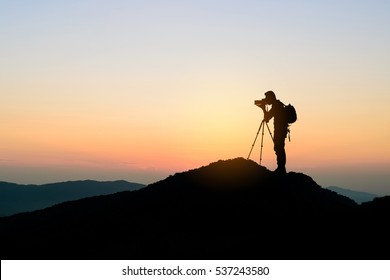 silhouette of photographer on top of mountain at sunset background - Powered by Shutterstock