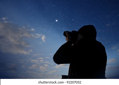 silhouette of photographer shooting night stars