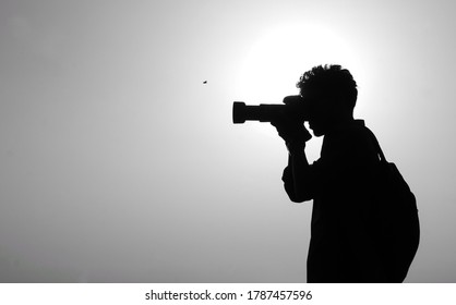 Silhouette photographer with white background. Photographer captured when he took photoshoot. Chattogram, Bangladesh / 2018.