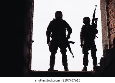 Silhouette Photos Of The Ukrainian Military. Brothers In Arms, A Man And A Woman With Weapons In Their Hands.