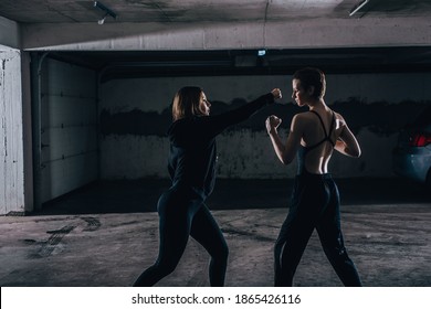 Silhouette-Bild von zwei jungen Frauen, die in der Garage kämpfen.