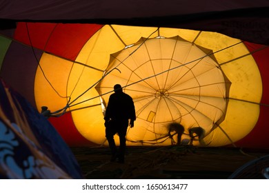 Silhouette of a pilot and crews checking inside the balloon before taking off at Singha Park in Chiang Rai, Thailand.
