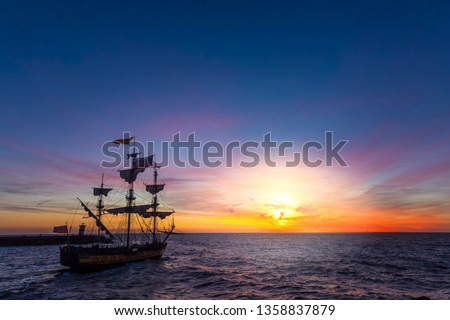 Silhouette of a pirate ship leaving the harbor for a long campaign on the ocean chasing, pirating other marchand ship 