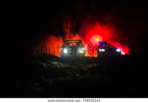 Silhouette of police car chasing a car at night\
with fog background. 911 Emergency response police car speeding to\
scene of crime. Selective\
focus