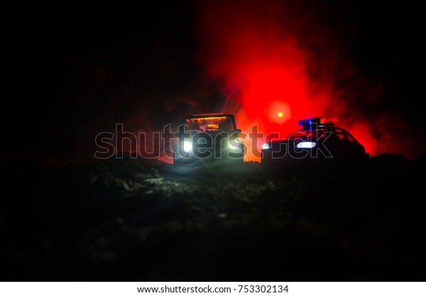 Silhouette of police car chasing a car at night\
with fog background. 911 Emergency response police car speeding to\
scene of crime. Selective\
focus
