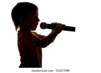 silhouette portrait of little child singing karaoke into microphone on white isolated background
