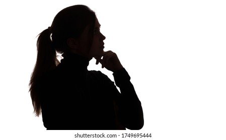 Silhouette Portrait Of A Pensive Girl With Hand Under Chin , Young Woman On White Isolated Background Thinking