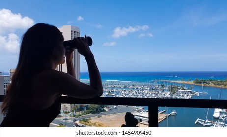 Silhouette portrait of women taking the binoculars from the condo balcony to exploring views of the city in the Magic island,Hawaii. - Powered by Shutterstock