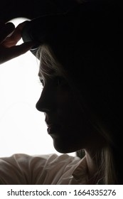 Silhouette Portrait Of Young Female Model In White Shirt And Hat. Noir Photography Concept.