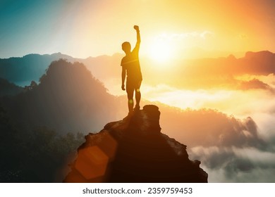 Silhouette of positive man celebrating on mountain top, with arms raised up, silhouette of man standing on the hill, Business, success,victory,leadership,achievement concept. Freedom travel adventure.
