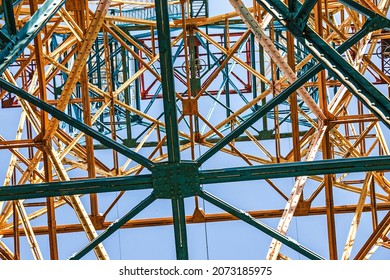 Silhouette Of A Power Line Pylon Against The Blue Sky. Transmission Of Electricity From The Power Plant To The City. Unusual Angle. Bottom View.