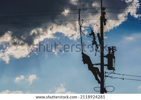 The silhouette of power lineman replacing a transformer and hotline clamp, bail  clamp. Using clamp stick grip all type, wearing personal protective equipmen,