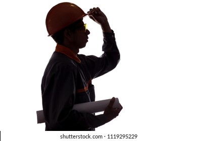 Silhouette Profile Of Construction Worker With Project In Hands, Man In Overalls In Hard Hat And Safety Glasses On White Isolated Background,concept Of Building, Heavy Industry, Profession