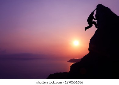 Silhouette purple of man climbing rock, Photographer on the mountain at sunrise,Archipelago island in Thailand