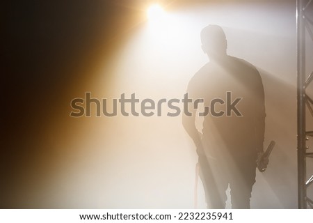 Silhouette of rap singer with microphone in hand. Rapper on concert stage