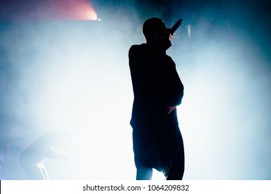 Silhouette Of The Rapper On The Stage. Bright Stage Light And Smoke In The Background.