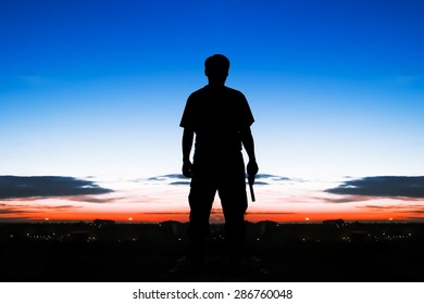 Silhouette Rear Of Man Standing Hand Hold Holding Gun Revolvers On Sunrise In The City Background