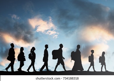 Silhouette Of Refugees People With Luggage Walking In A Row