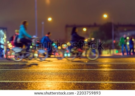 Silhouette of riding cyclists. Parade of bicyclists in city, night, abstract, motion blur. Modern active lifestyle, healthy lifestyle concept