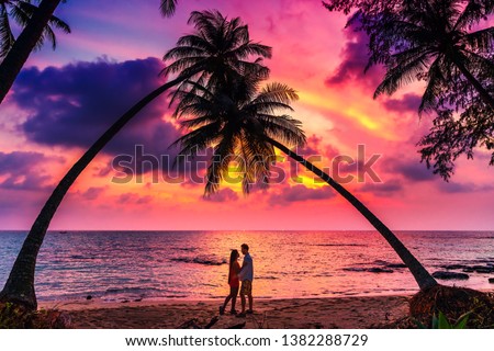 Silhouette of romantic affectionate couple kissing at sunset sea beach. Dating and relationship background with copyspace. Man and woman in love in honeymoon vacation.