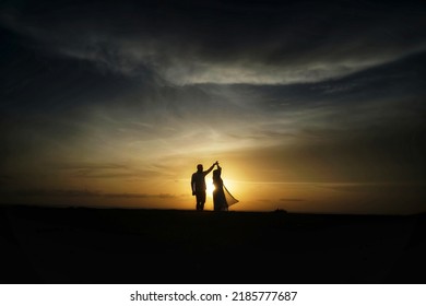 Silhouette of romantic couple dance on the beach at beautiful sunset time - Powered by Shutterstock