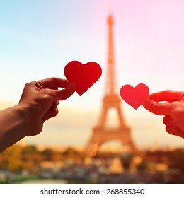 Silhouette Of Romantic Lovers Hand Hold Love Heart Paper With Eiffel Tower In Paris With Sunset