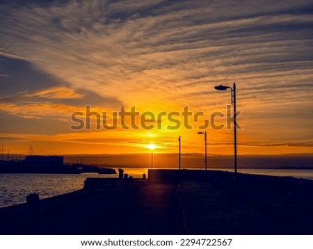 Silhouette of a rough coastline at sunrise. Warm and cool color. Nobody. Stunning nature scene. Galway bay, Ireland. Nimnos pier.