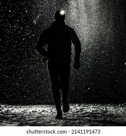 Silhouette Of Running Man With Headlight, With Snow On Background, At Night, In Winter