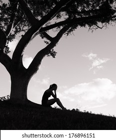 Silhouette Of Sad Woman Sitting Under The Tree
