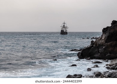 Silhouette of sailing boat ship on the majestic Atlantic Ocean seen from beach Praia Santa Cruz, Madeira island, Portugal, Europe. Sunlight reflection on the calm water surface of the sea. Tranquility - Powered by Shutterstock