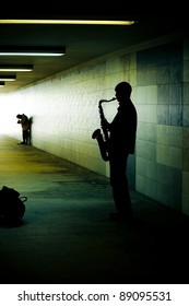 Silhouette Of A Saxophonist In The Subway Tunnel