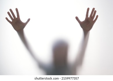 Silhouette Scared Boy Stand Behind Glass Door. Kid Showing Two Hands. Background Representing Dangerous, Fear, Help, Haunting, Horror And Panic. Teen Problems, Negative Emotions Concept.