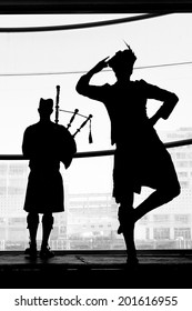 Silhouette Of A Scottish Highland Dance Dancer Dancing To A Bagpipe Music. Real People. Copy Space 