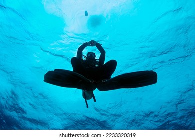 Silhouette of scuba diver completing safety stance with SMB device deployed. Bubble underwater. Bubbling divers. Scuba Diver Facing Surface at Safety Stop. Daedalus reef, Egypt. - Shutterstock ID 2233320319
