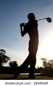 Silhouette of senior man driving golf ball