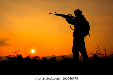 Silhouette shot of soldier holding gun - Shutterstock ID 166646795