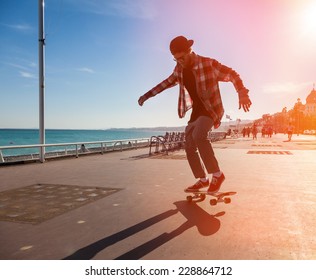 Silhouette of Skateboarder jumping in city on background of promenade and sea - Powered by Shutterstock