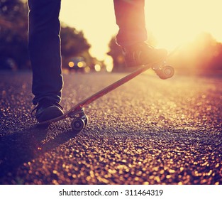  Silhouette of Skateboarder jumping in front of a beautiful sunset on a freshly tarred road toned in a retro vintage instagram filter effect app or action  - Powered by Shutterstock