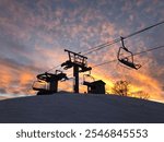 Silhouette of Ski Lift Chairs at Sunset with Vibrant Colorful Sky on Snowy Slope