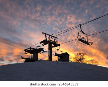 Silhouette of Ski Lift Chairs at Sunset with Vibrant Colorful Sky on Snowy Slope - Powered by Shutterstock