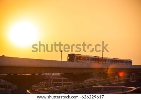 silhouette of sky train is running on the evening with flare.